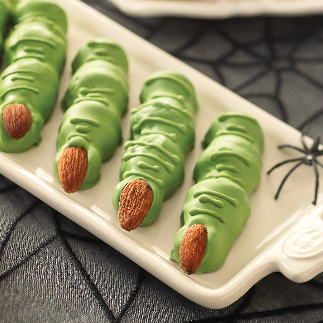 Green candy witches fingers on a tray decorated for Halloween