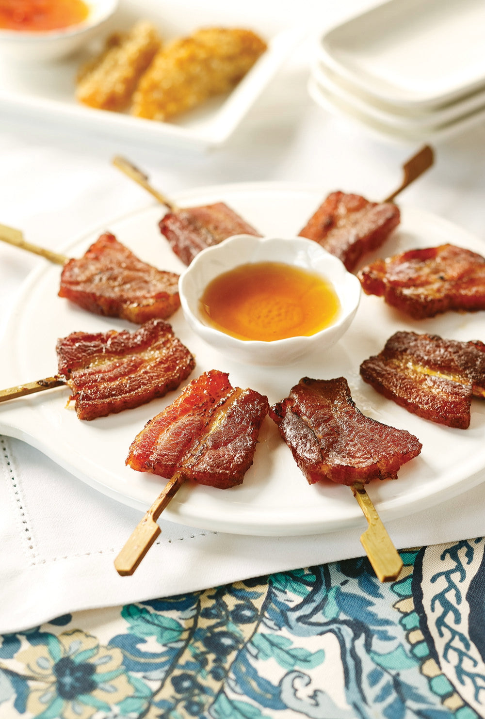 Bacon Lollipops on a white plate with sweet dipping sauce