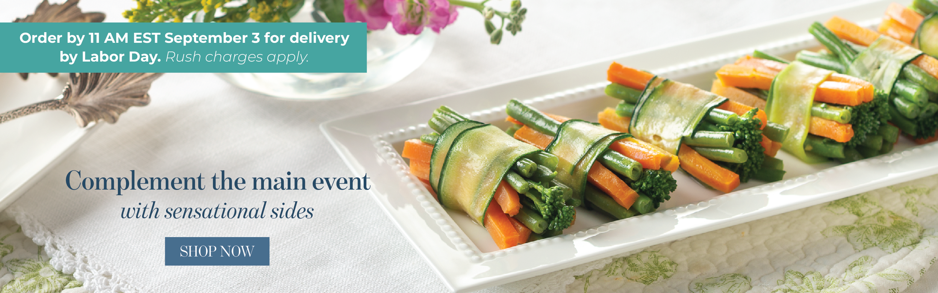 A long white rectangular platter holding several broccoli and carrot wraps in a glossy sauce, set on a white tablecloth. Shop sensational sides. Order by 11am on September 3 for delivery by Labor Day.